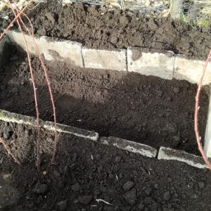 Bed uitgraven en afschermen met stoeptegels